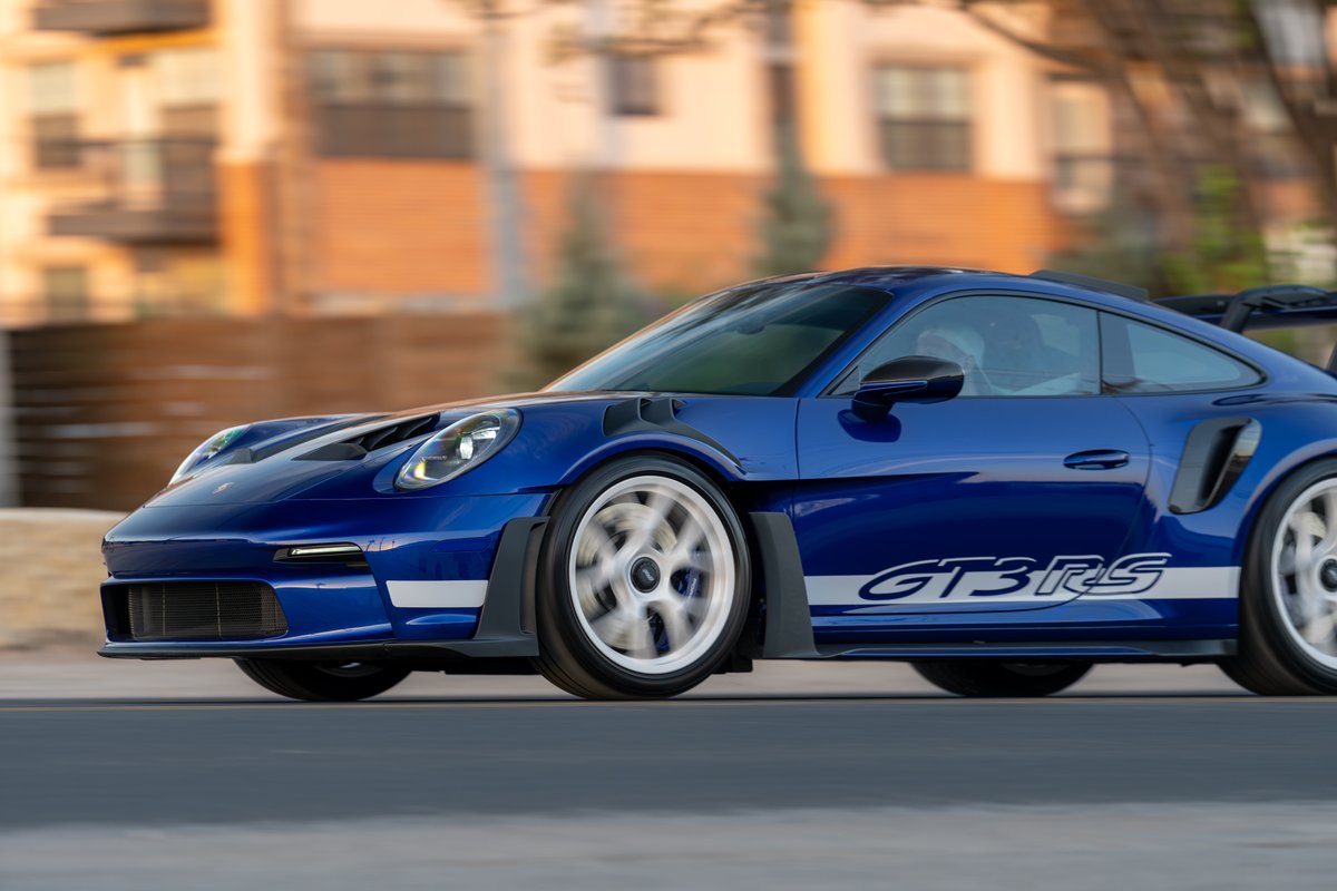 Blue 2025 Porsche 911 GT3 RS with white GT3 RS livery and white rims in motion.