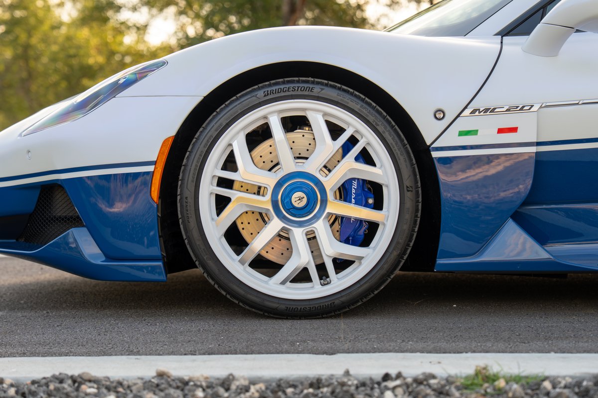 White 2024 Maserati MC20 with blue trim, white rims, blue calipers, and Italian flag livery.
