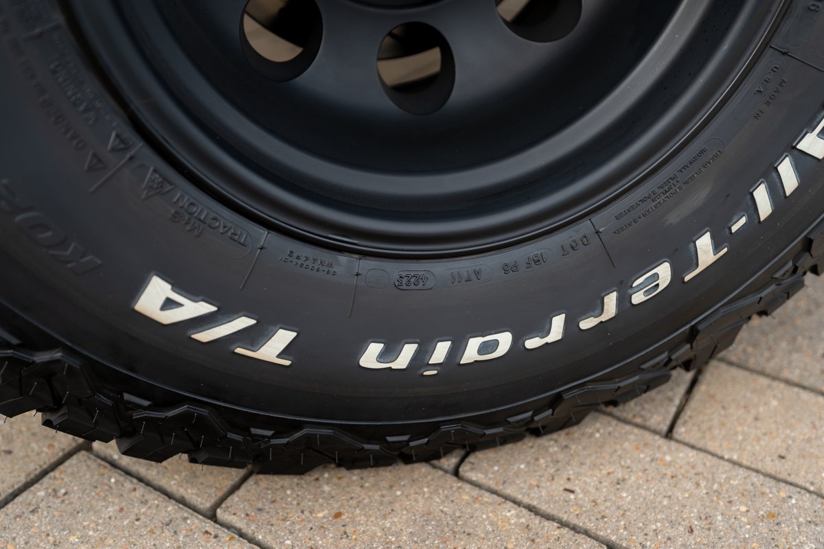 BFGoodrich All-Terrain T/A tires on a black rim of a 1966 Ford Bronco.