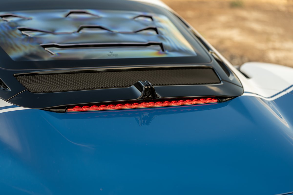2024 Maserati MC20 Icona in blue with white stripe, showing rear brake light and camera.