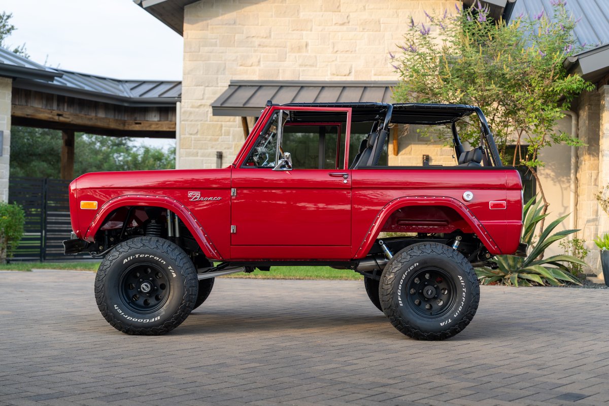 1966 red Ford Bronco by Atlas Broncos with black rims and BFGoodrich All-Terrain T/A tires.