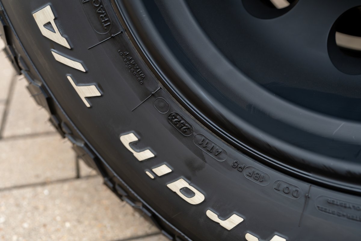 Close-up of a BFGoodrich tire on a black steel rim of a 1966 Ford Bronco.