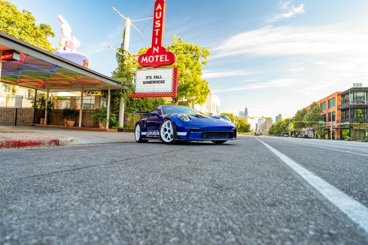 Blue 2025 Porsche 911 GT3 RS with white center lock rims and racing livery.