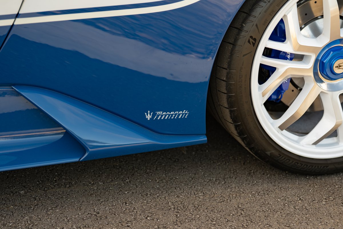 Close-up of a 2024 Maserati MC20 Icona in blue with white livery, showing the FUORISERIE badge, white rims, and blue calipers.