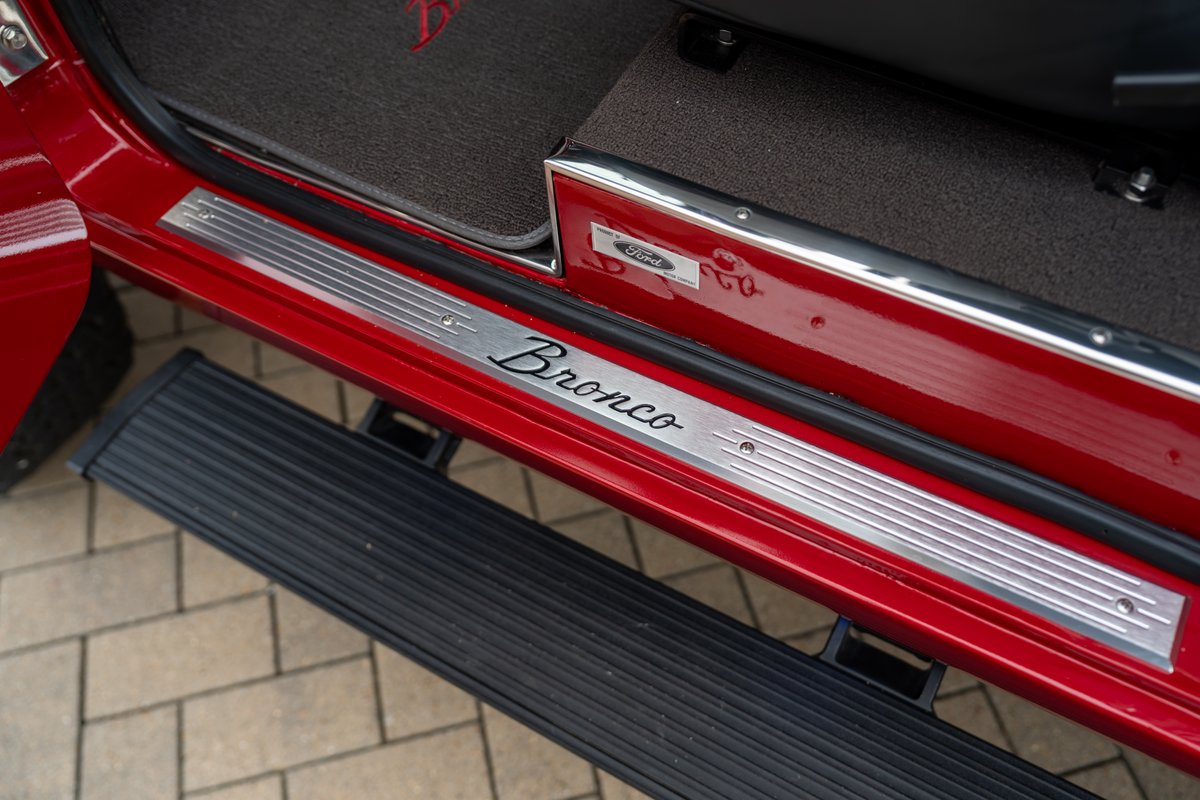 1966 Ford Bronco door sill with brushed aluminum "Bronco" script and Ford badge.