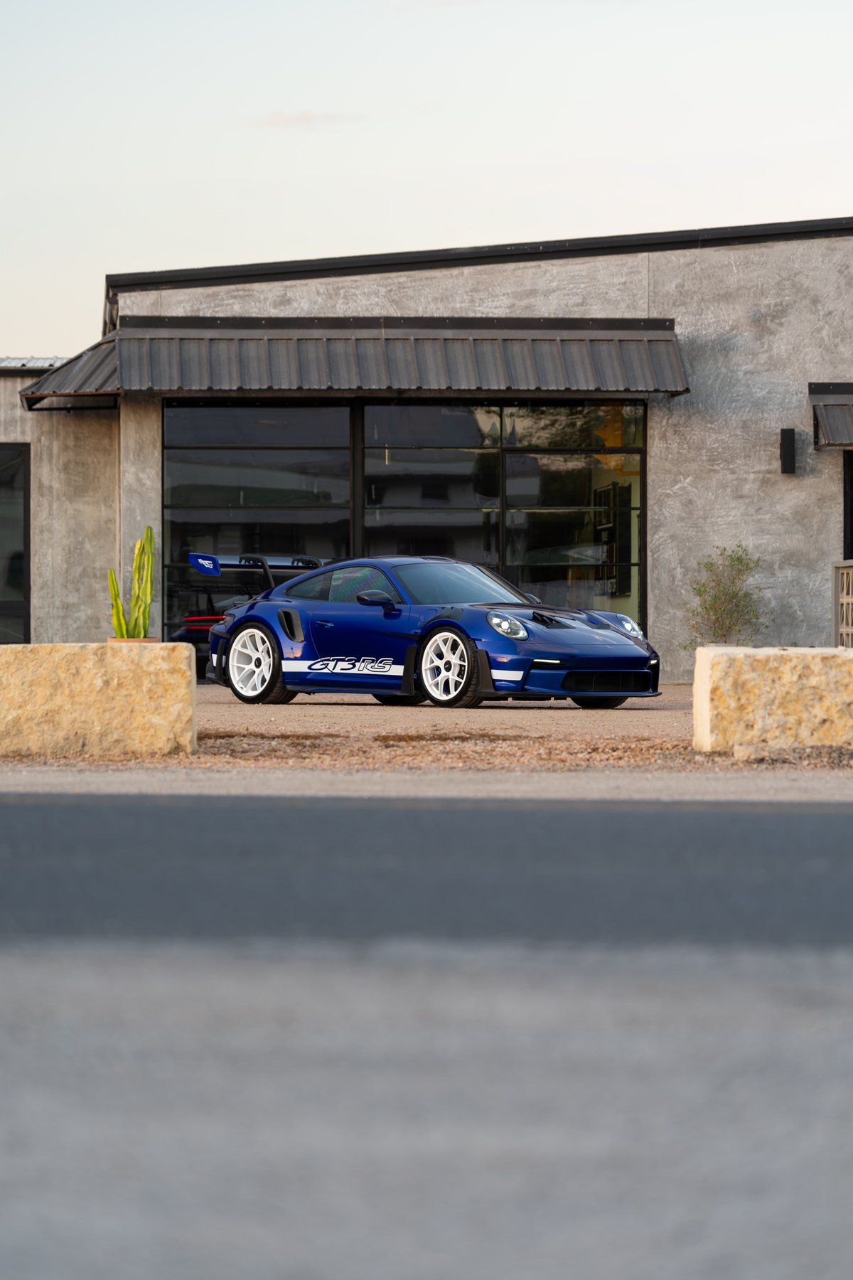 2025 Porsche 911 GT3 RS in blue with white GT3 RS livery, white center-lock rims.