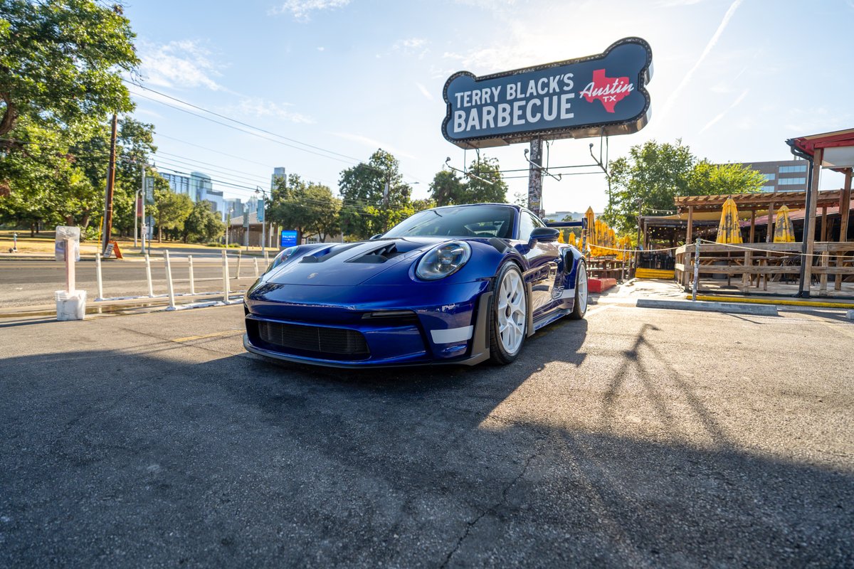 2025 Porsche 911 GT3 RS in blue with white racing rims and livery accents.