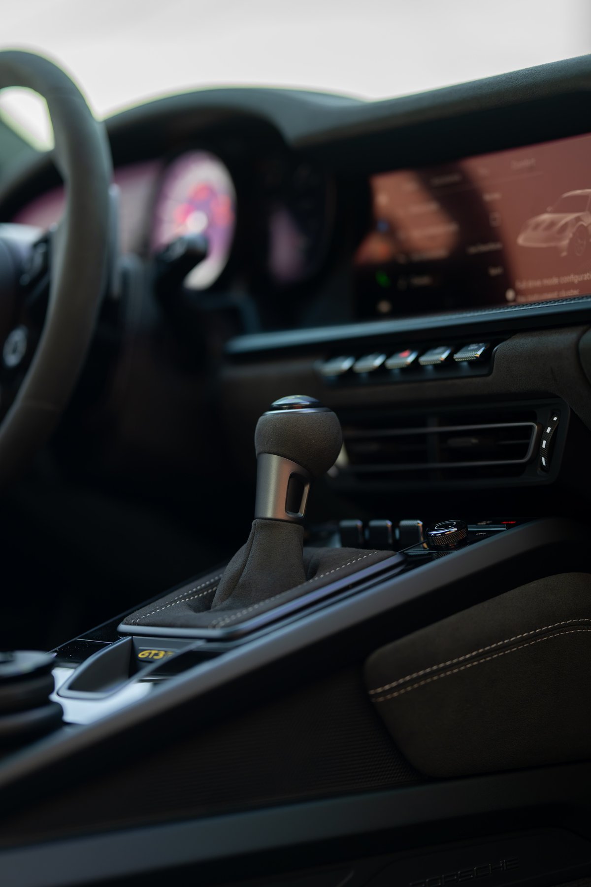 Close-up of the manual gear shifter in a 2025 Porsche 911 GT3 RS, with alcantara trim and stitched details.