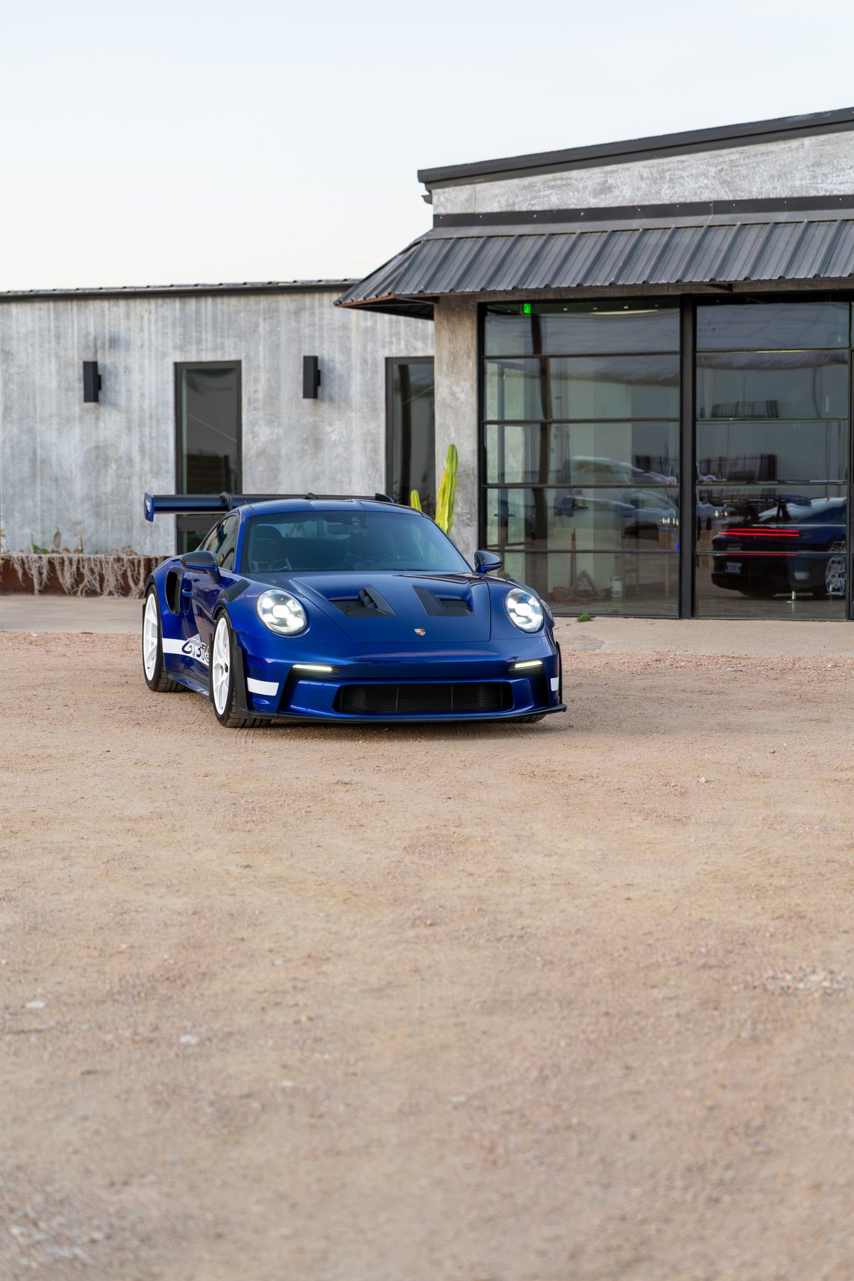 2025 Porsche 911 GT3 RS in blue, featuring white racing livery and white rims.