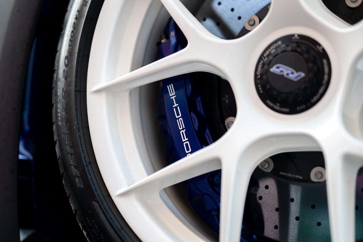 White 5-spoke rims on a blue 2025 Porsche 911 GT3 RS with blue "PORSCHE" brake calipers.