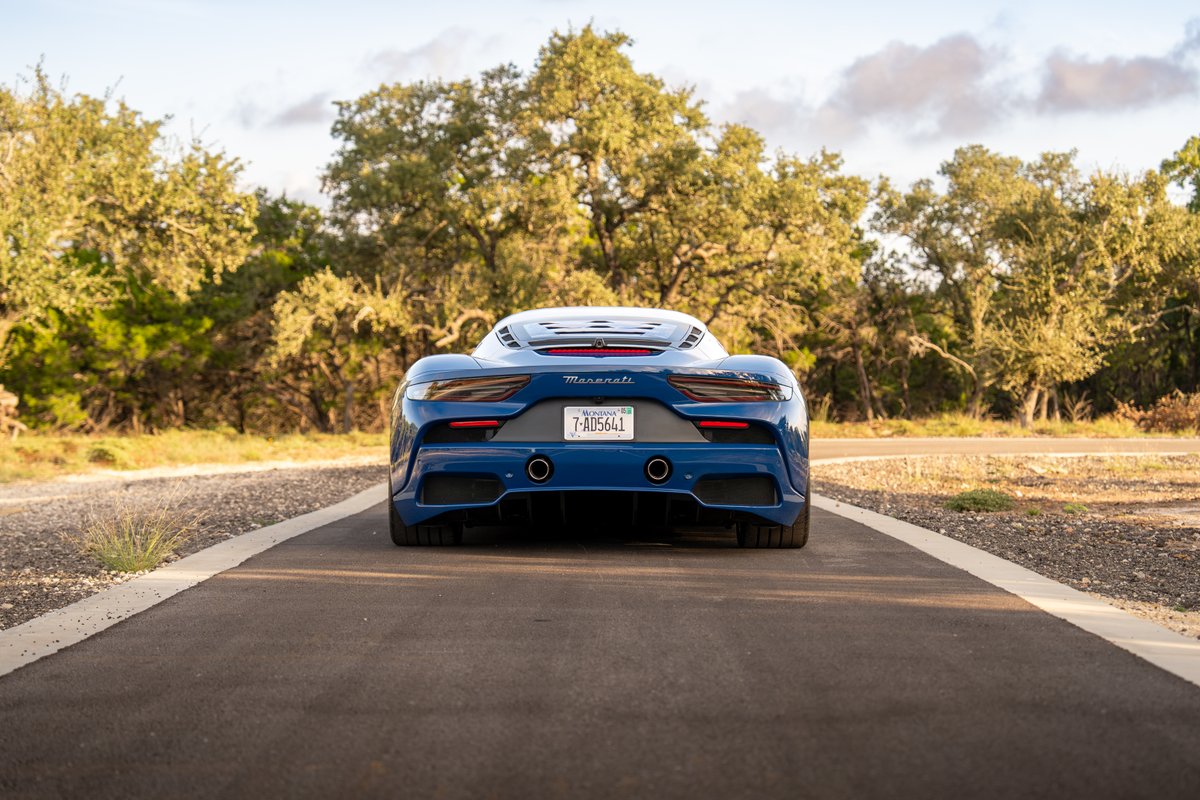 2024 Maserati MC20 Icona in blue, rear view, with distinctive dual exhaust pipes and sculpted diffuser.