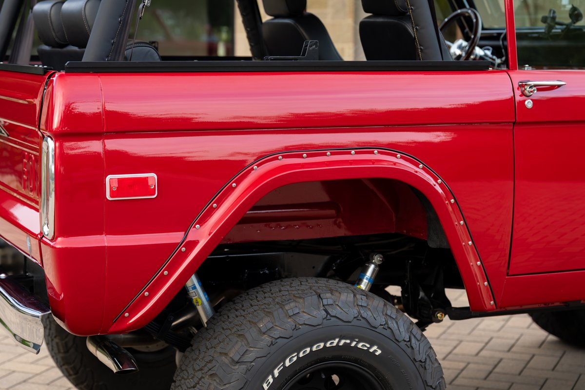 Red 1966 Ford Bronco with riveted fender flares and BFGoodrich tires.