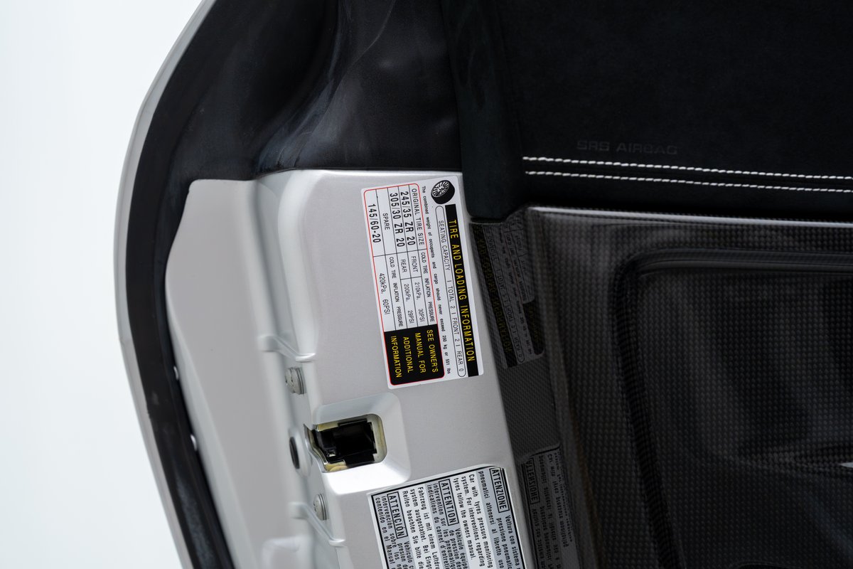 2015 Ferrari 458 Speciale doorjamb with tire pressure sticker and carbon fiber trim.