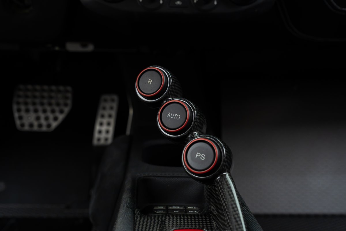 Close-up of the 2015 Ferrari 458 Speciale's carbon fiber gear selector buttons: R, Auto, PS.