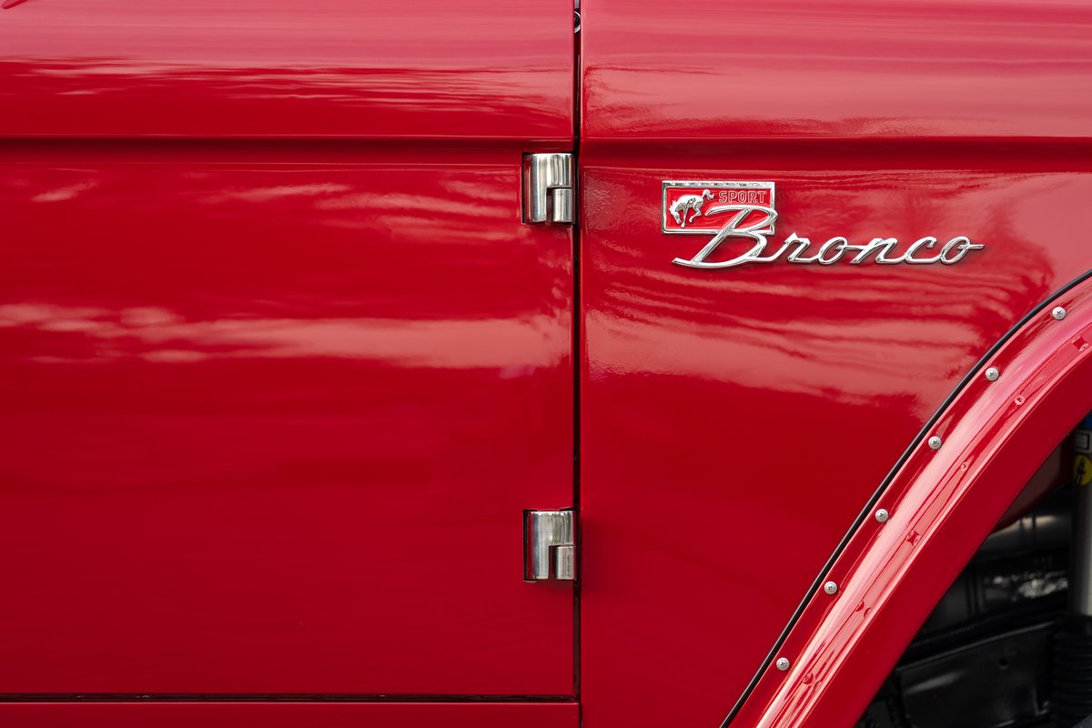 Close up of a red Ford Bronco Sport emblem and fender trim.