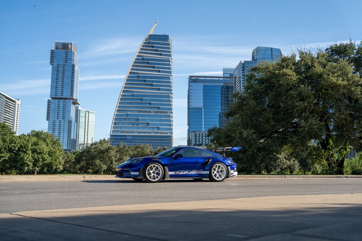 A blue 2025 Porsche 911 GT3 RS with white racing livery and white rims is parked.
