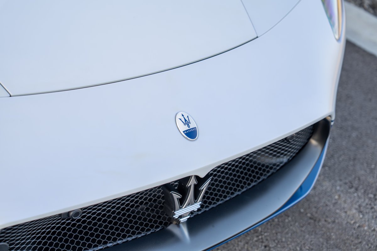 Front view of a white 2024 Maserati MC20 Icona with its signature trident emblem on the grille.