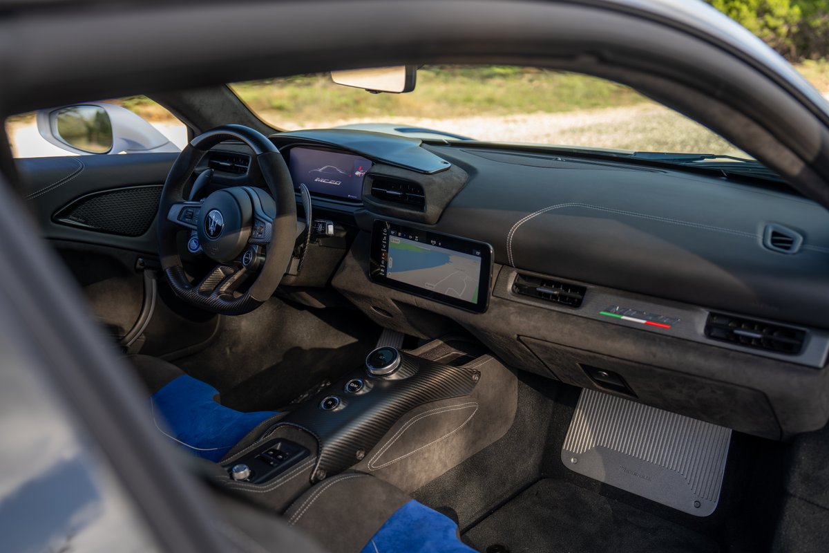 2024 Maserati MC20 Icona interior with carbon fiber trim, digital displays, and Italian flag livery.