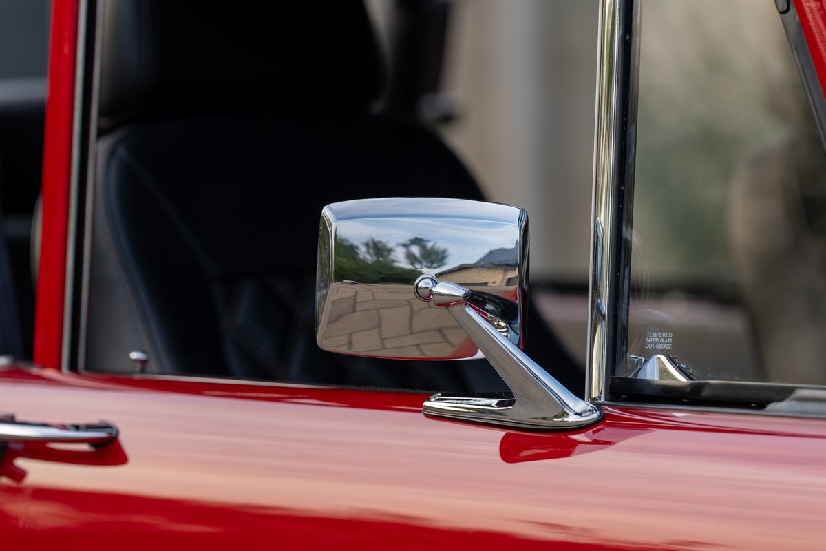 1966 Ford Bronco exterior, red paint, chrome side mirror, and tempered glass window.