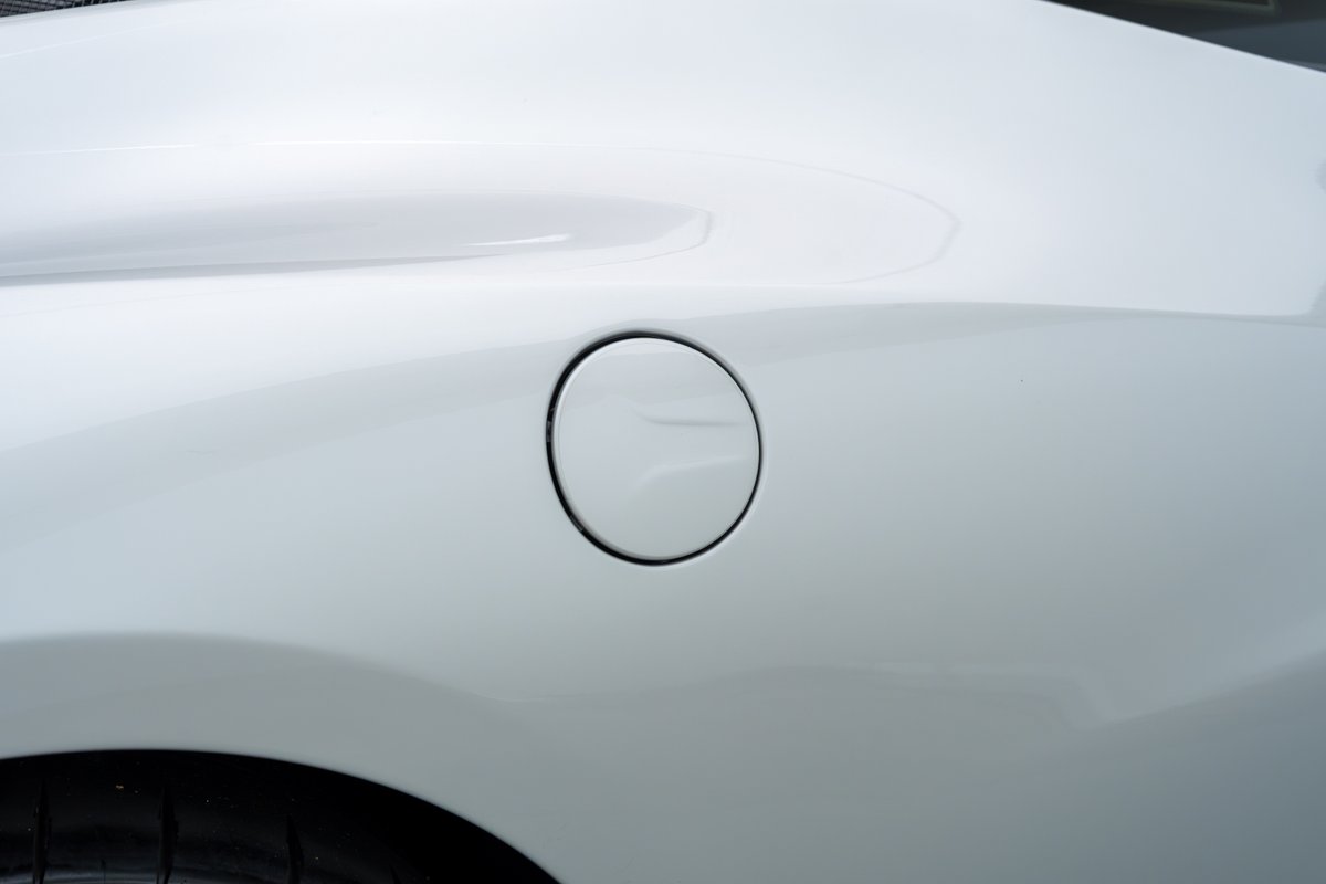 Close-up of a white 2015 Ferrari 458 Speciale's fuel filler door.