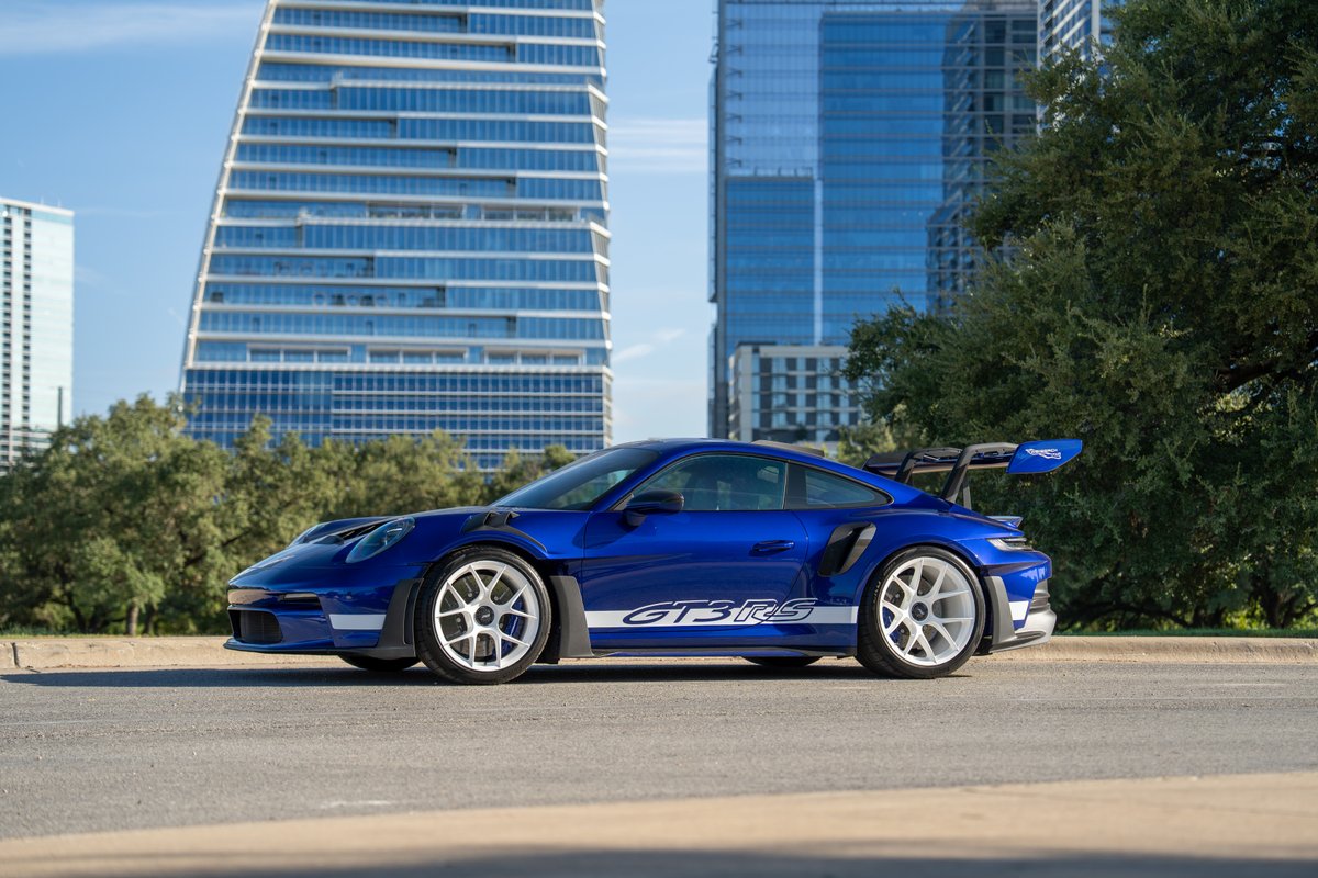 A blue 2025 Porsche 911 GT3 RS with white "GT3RS" side livery and white multi-spoke rims.