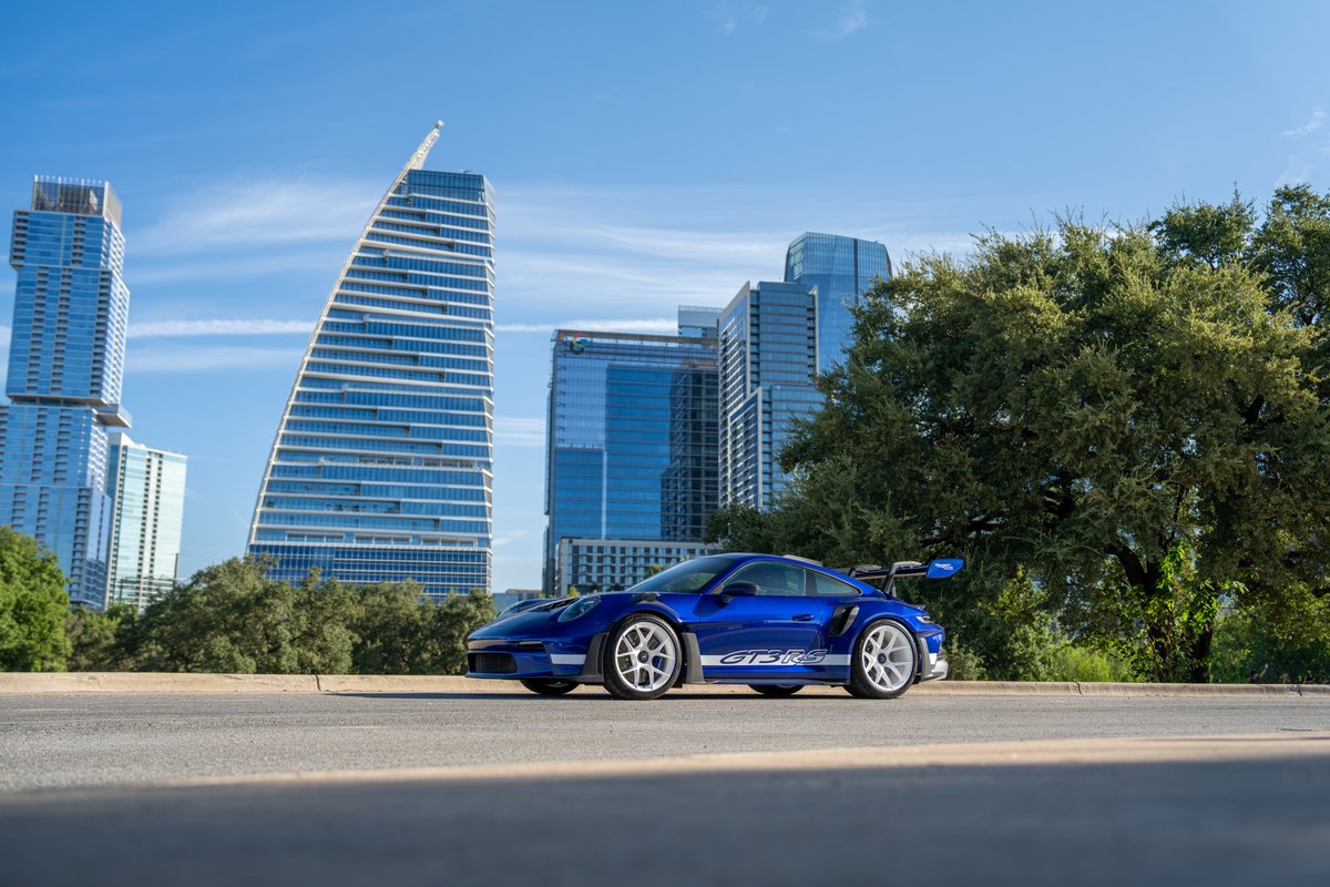 Blue 2025 Porsche 911 GT3 RS with white rims and "GT3 RS" livery.