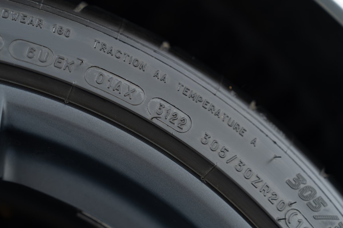 Close-up of a 2015 Ferrari 458 Speciale tire, showing 305/30ZR20 size, DOT 3122, and treadwear 180.