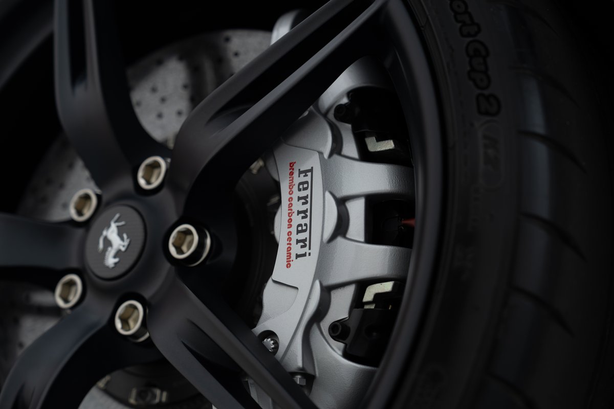 Close-up of the 2015 Ferrari 458 Speciale's black wheel, showing carbon ceramic brake caliper.