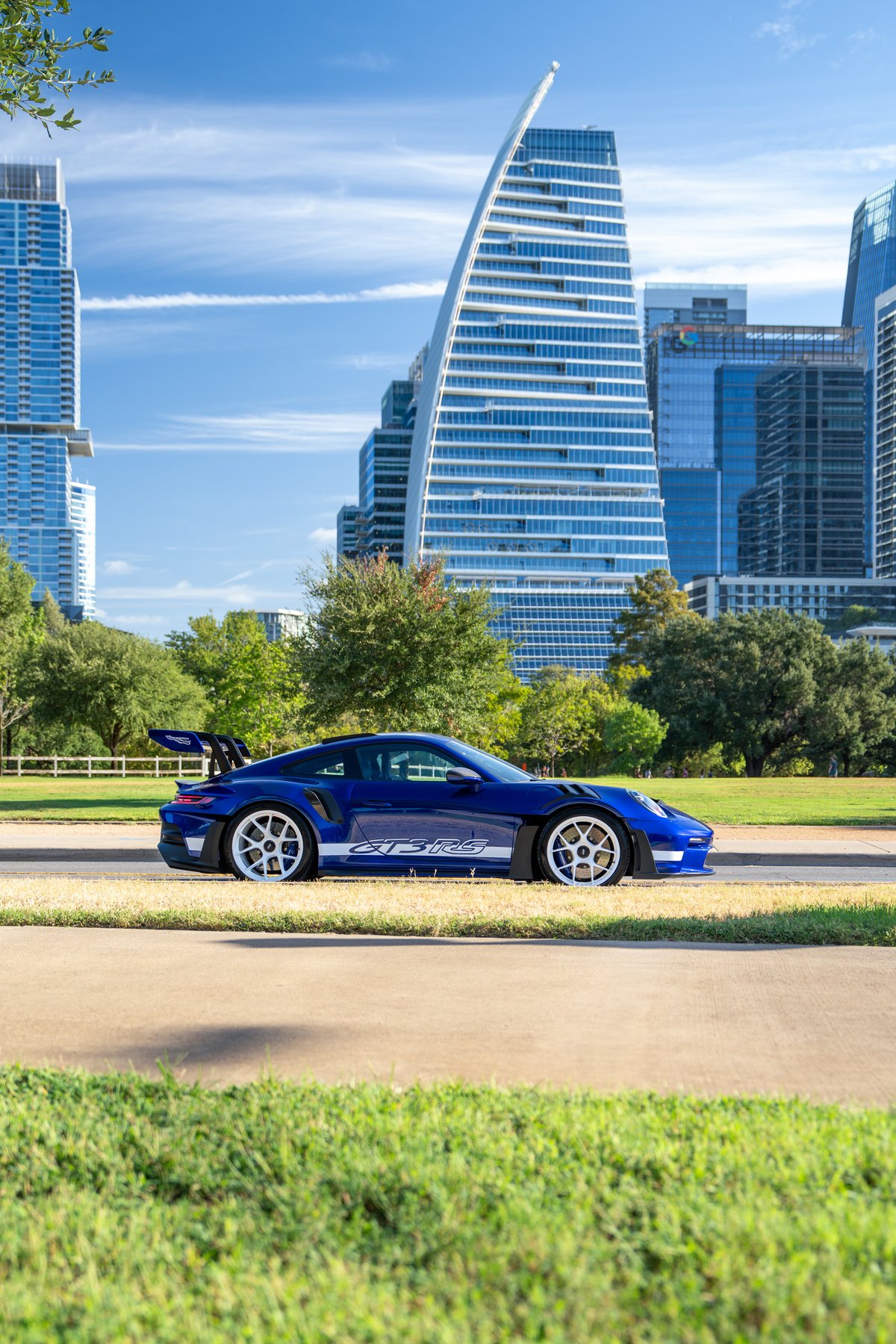 2025 Porsche 911 GT3 RS in blue with white accent livery and white center-lock rims.