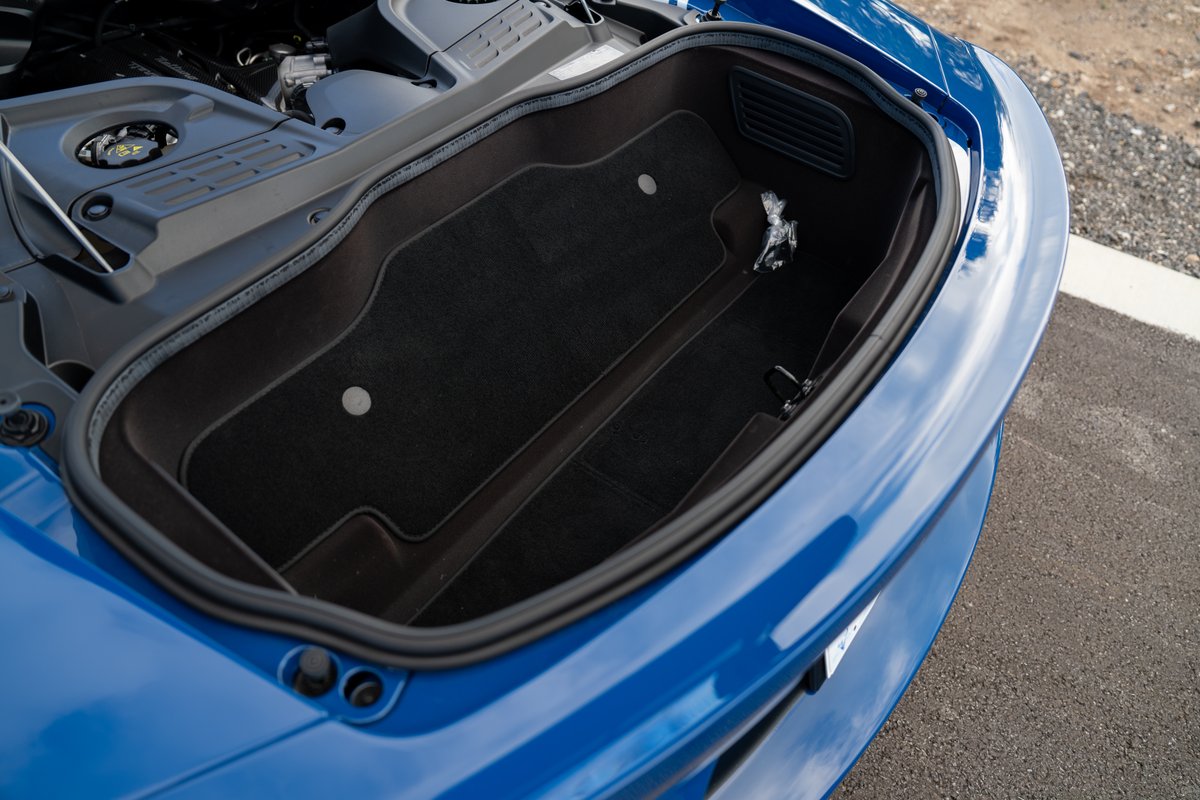 2024 Maserati MC20 Icona trunk. Blue exterior, black carpeted storage compartment.