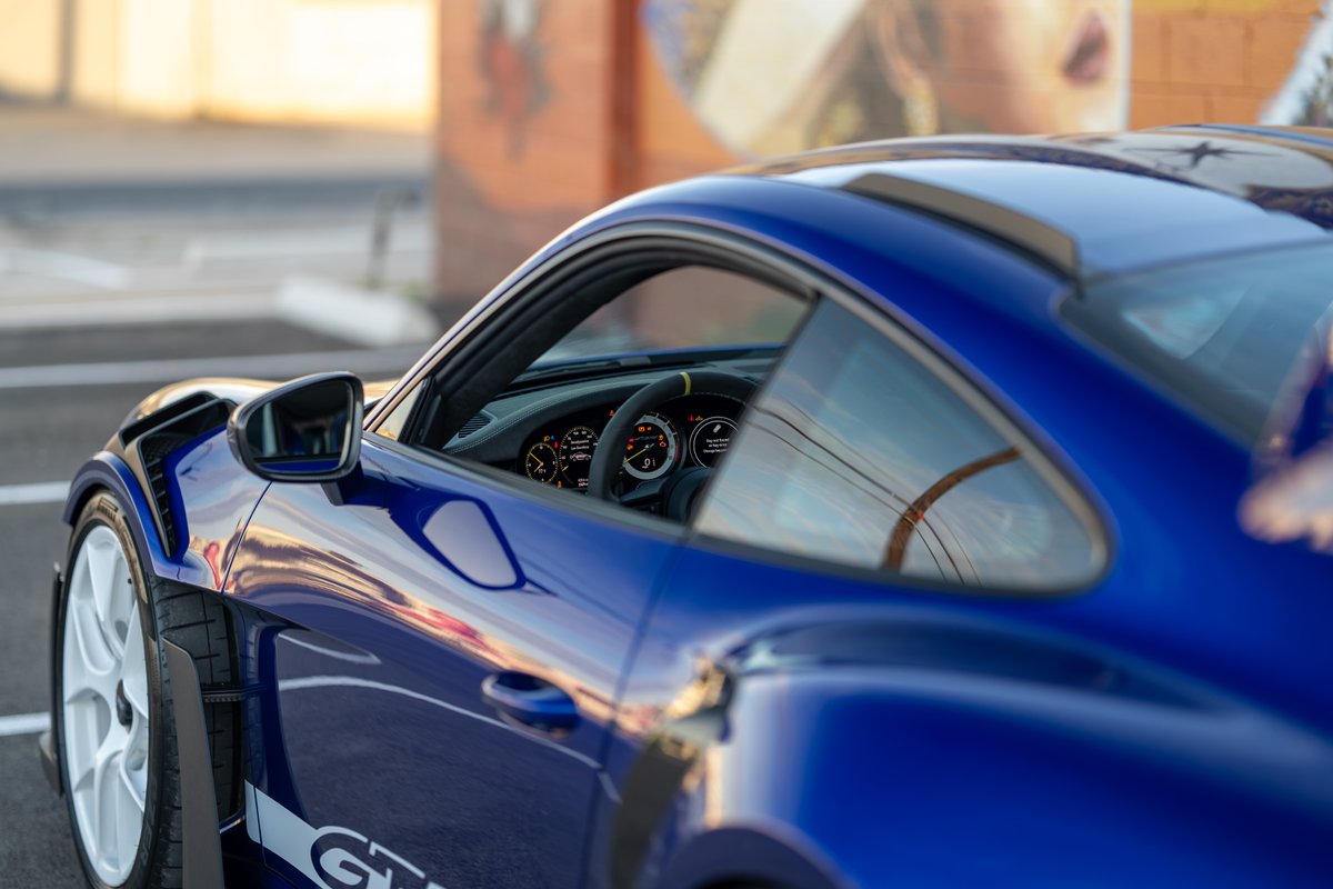 Blue 2025 Porsche 911 GT3 RS with white rims and "GT3 RS" livery.