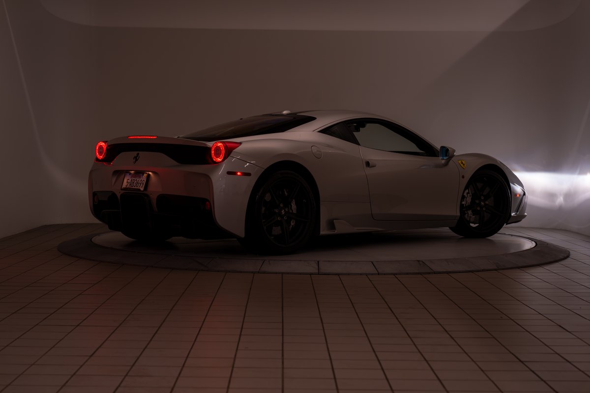 2015 silver Ferrari 458 Speciale with black rims and quad exhaust.