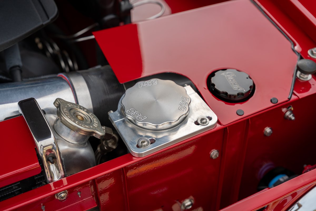 Custom red 1966 Ford Bronco engine bay with PSC billet aluminum caps.