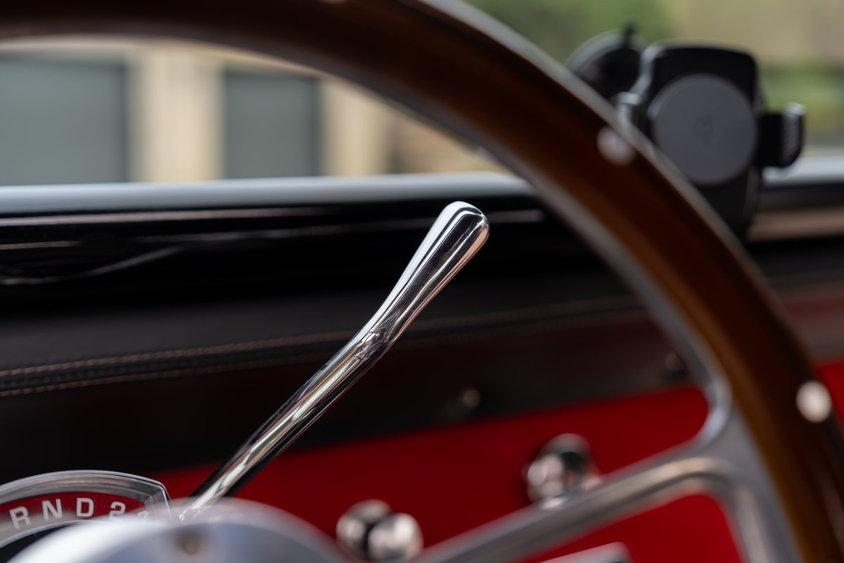 1966 Ford Bronco interior features a chrome automatic shifter and wood-grain steering wheel.