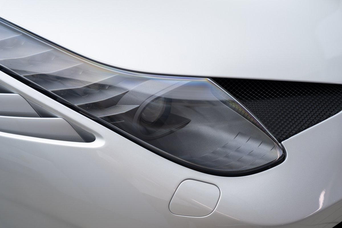 Close-up of the 2015 Ferrari 458 Speciale's intricate headlight and carbon fiber grille.