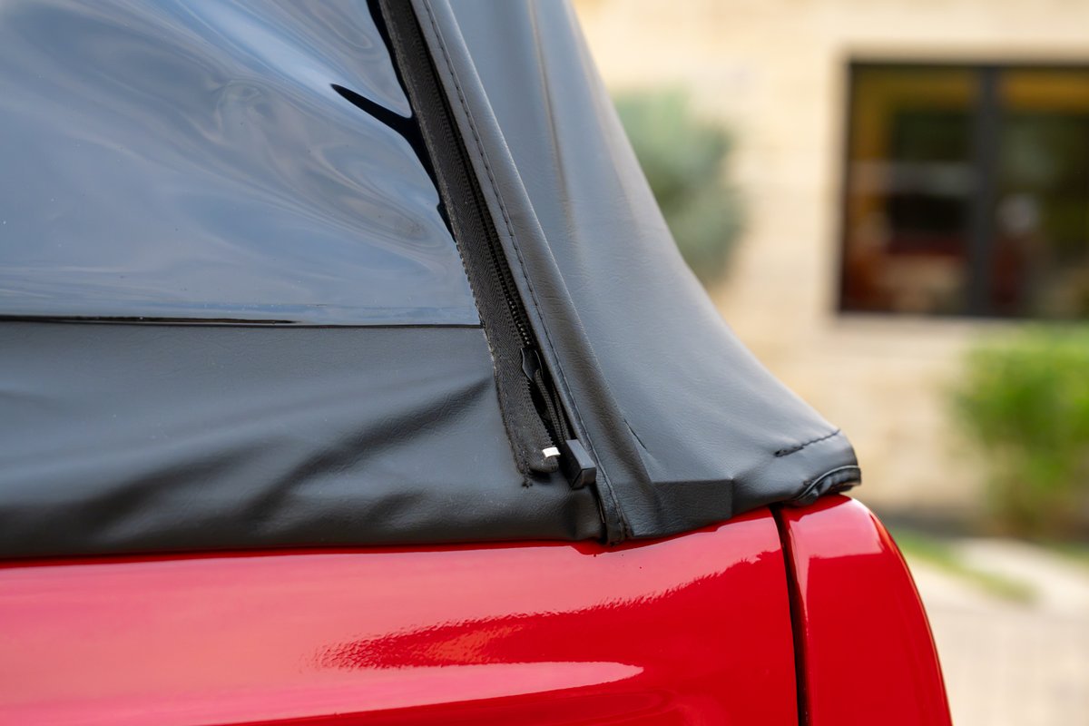 Close-up of a black soft top zipper on a red 1966 Ford Bronco.