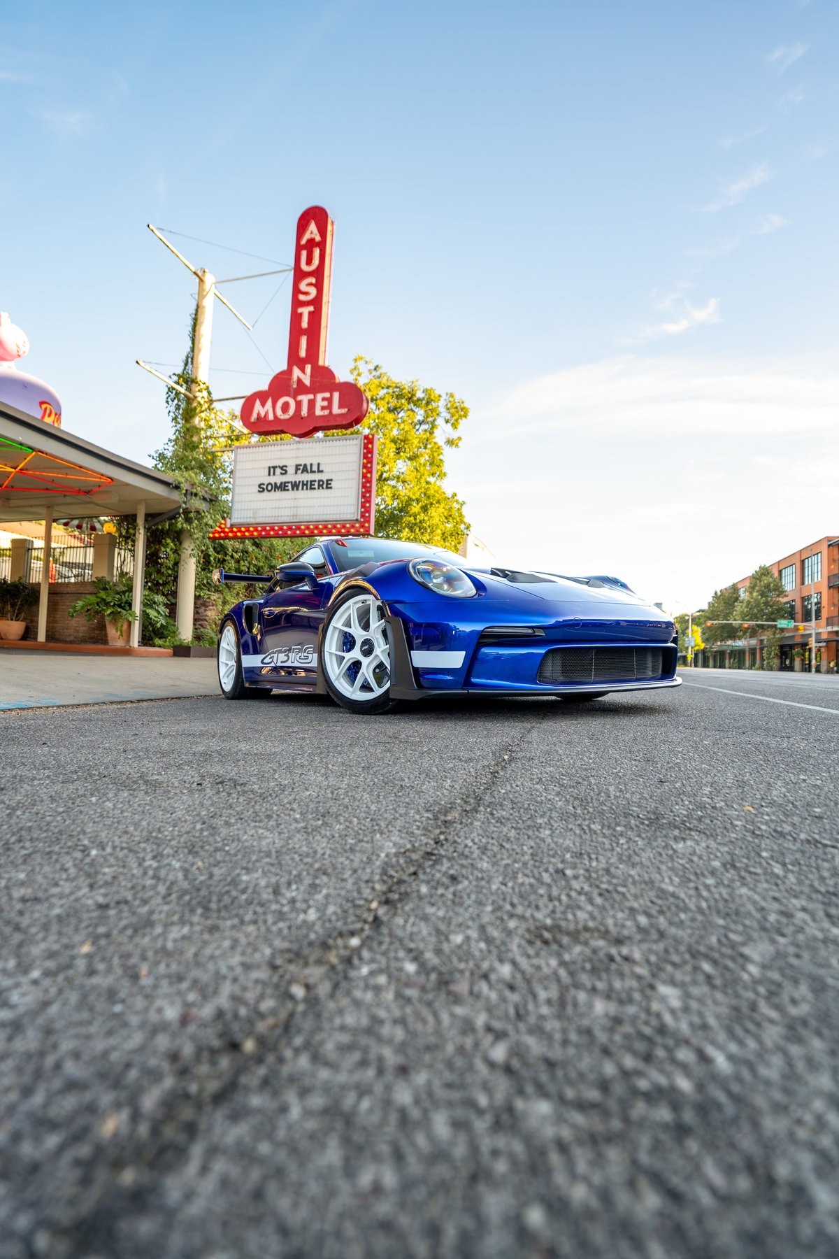 Blue 2025 Porsche 911 GT3 RS with white multi-spoke rims and track-focused aero trim.