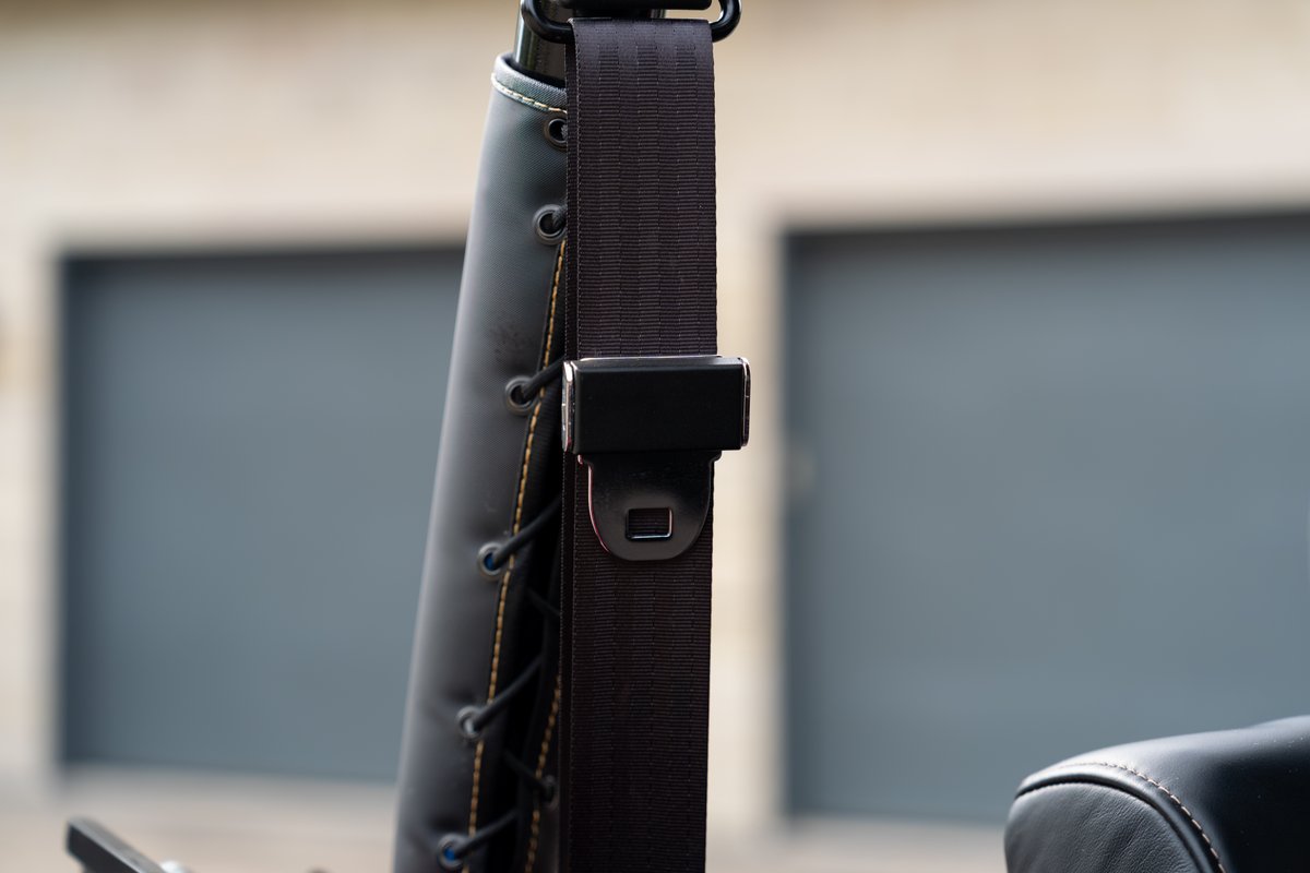 Black Atlas Broncos 1966 Ford Bronco seatbelt mechanism with black leather trim.