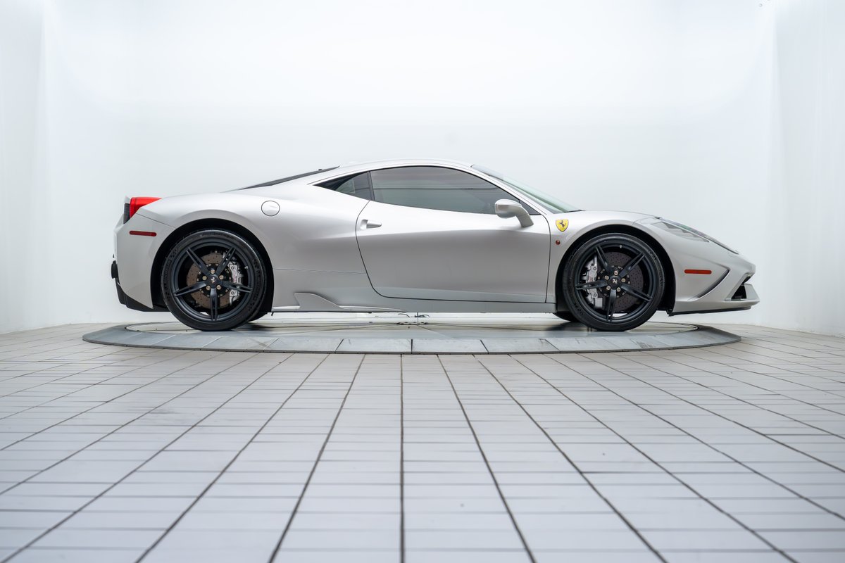 Silver 2015 Ferrari 458 Speciale with black rims and carbon ceramic brakes.