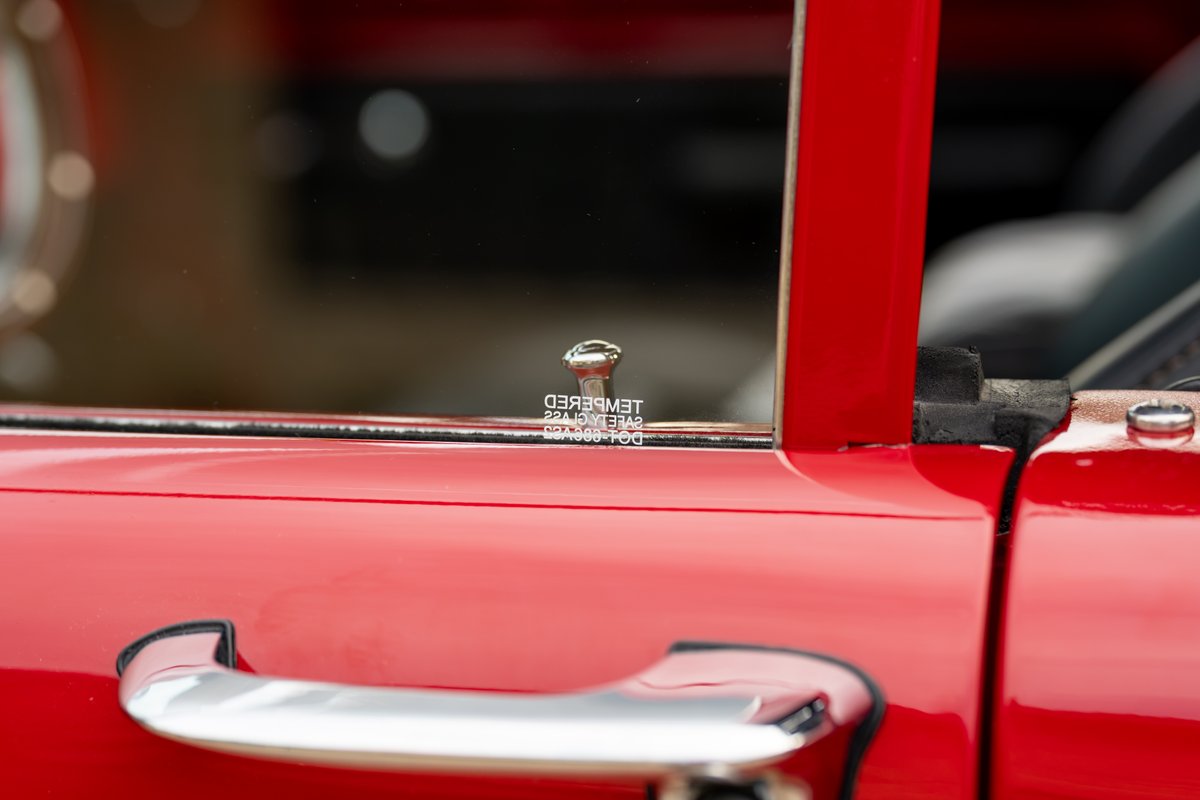 Red 1966 Ford Bronco door handle and tempered glass with DOT marking.