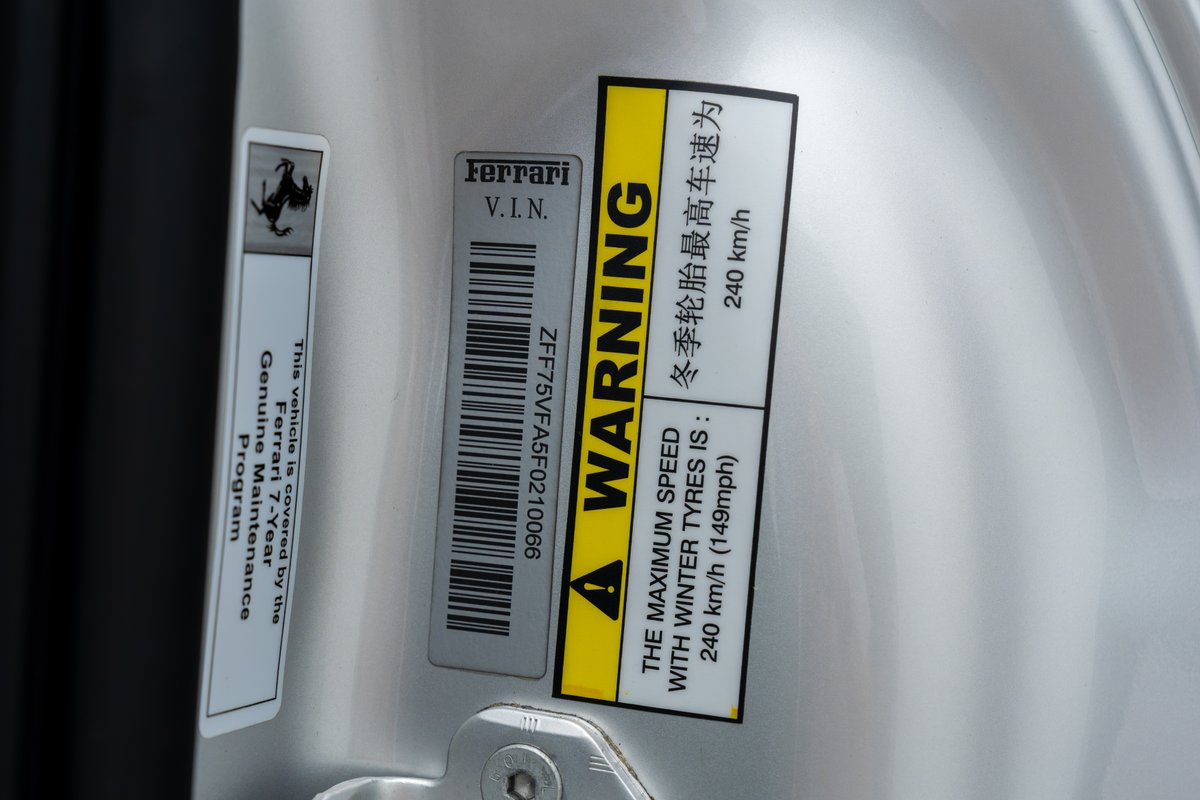 Silver 2015 Ferrari 458 Speciale VIN sticker with maintenance info.