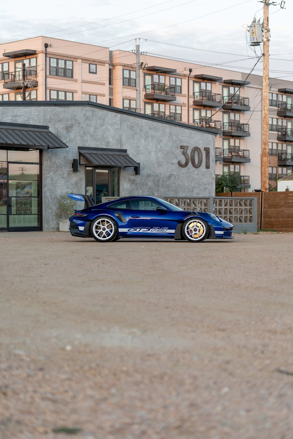 A blue 2025 Porsche 911 GT3 RS with white rims and GT3 RS side livery.
