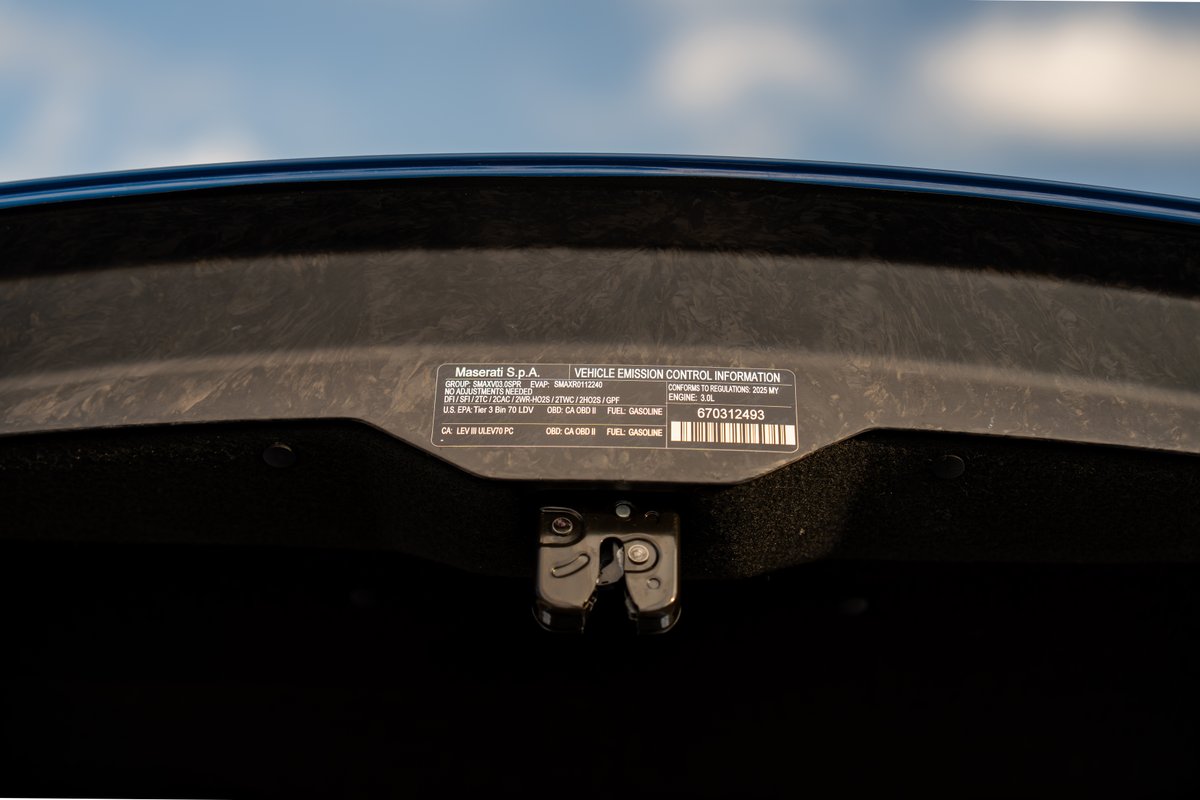 Maserati MC20 Icona: Close-up of the vehicle emission control information sticker under the hood.