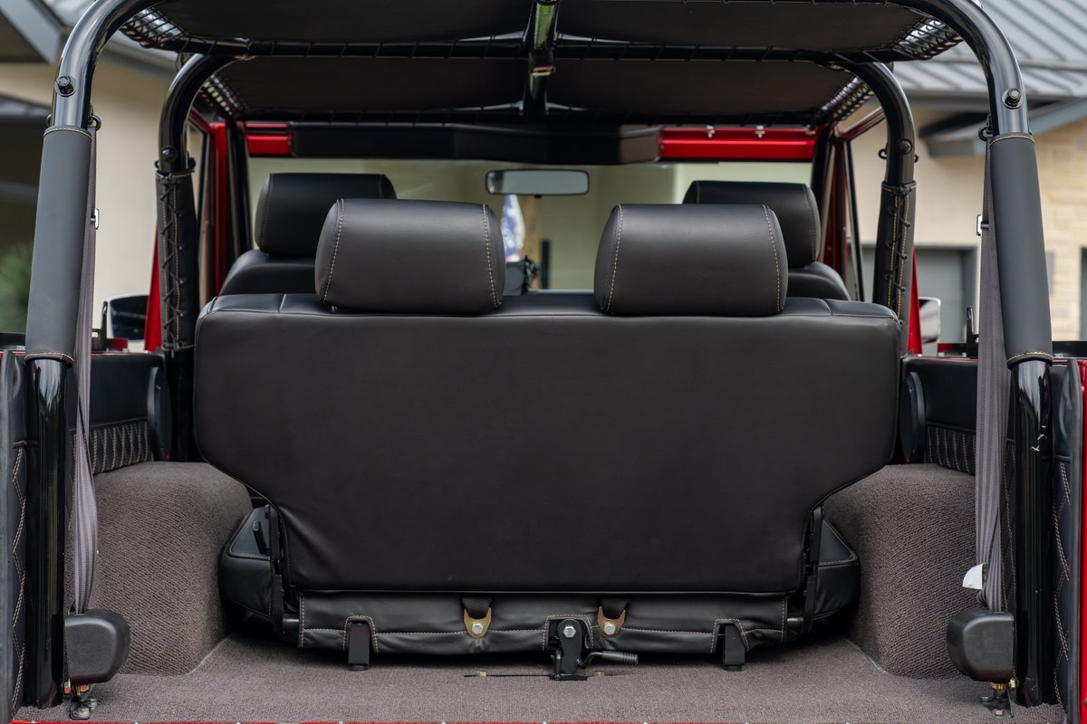 Back view of black leather rear seats in a red 1966 Ford Bronco by Atlas Broncos.