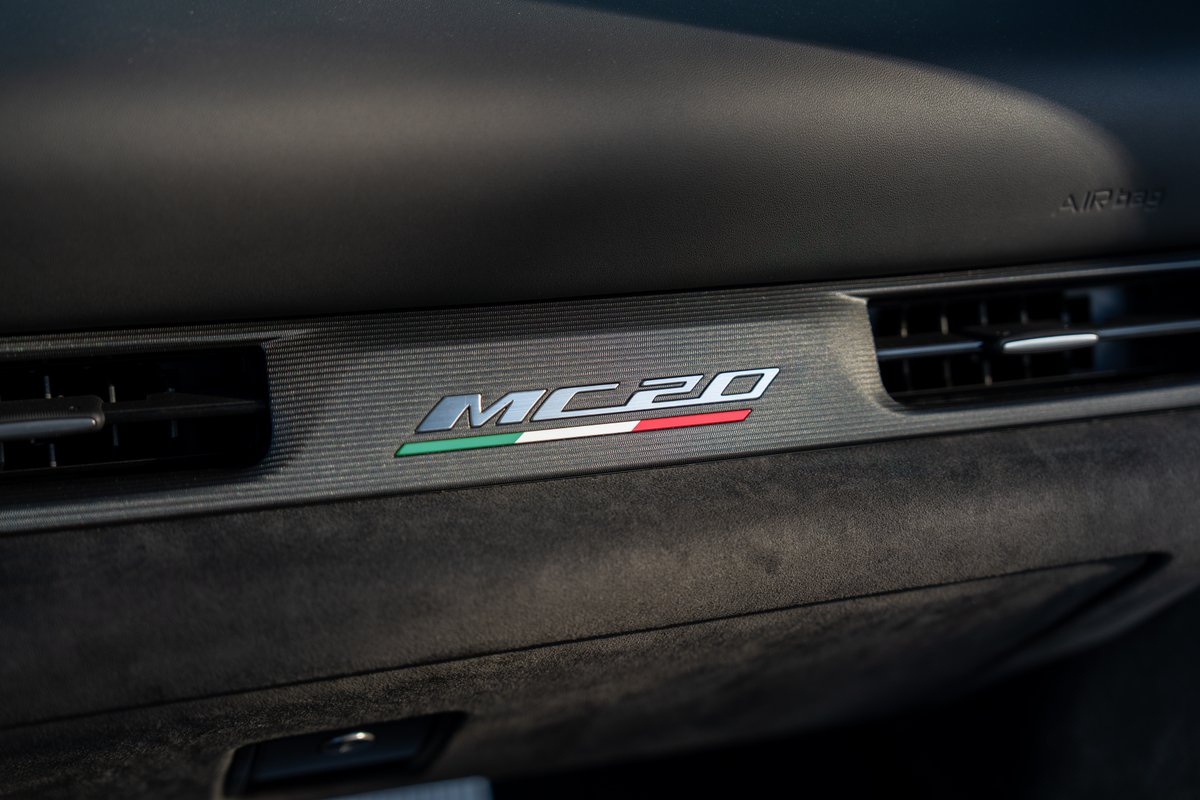 Close-up of a 2024 Maserati MC20 dash trim with MC20 badging featuring the Italian flag livery.
