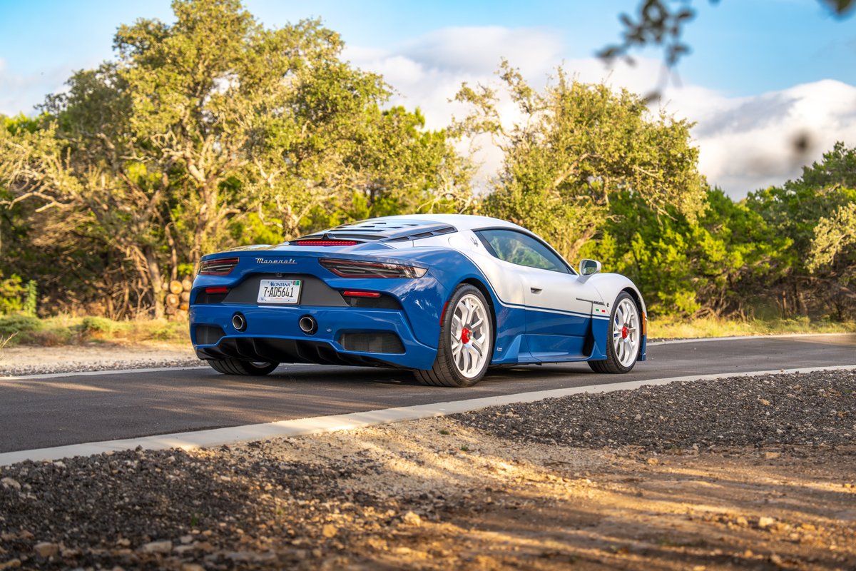 Rear view of the 2024 Maserati MC20 Icona in blue and silver livery, with distinctive red brake calipers and silver rims.