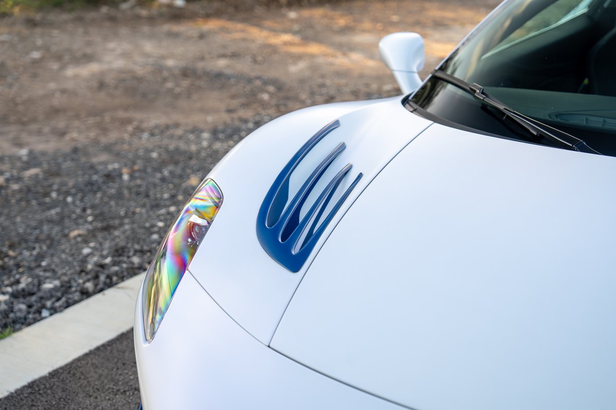 2024 Maserati MC20 Icona in white with blue trim and iridescent headlight details.