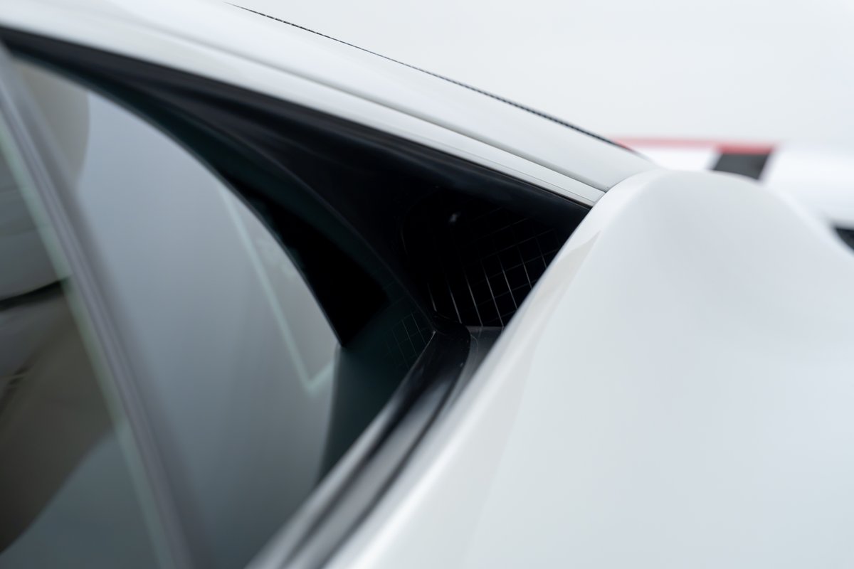 Close-up of white 2015 Ferrari 458 Speciale side vent and window trim.