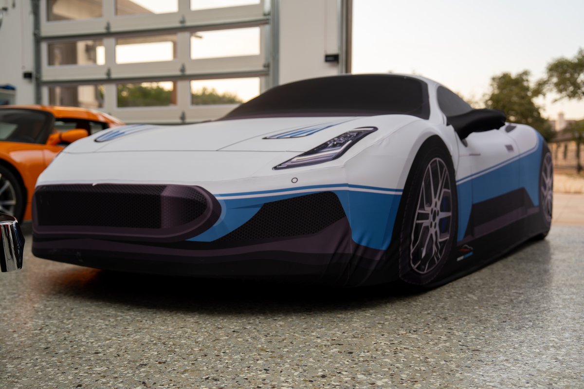 White 2024 Maserati MC20 Icona with blue stripe livery and multi-spoke rims.