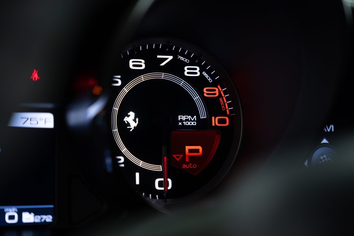 2015 Ferrari 458 Speciale dashboard with red "P" for park and illuminated RPM gauge.